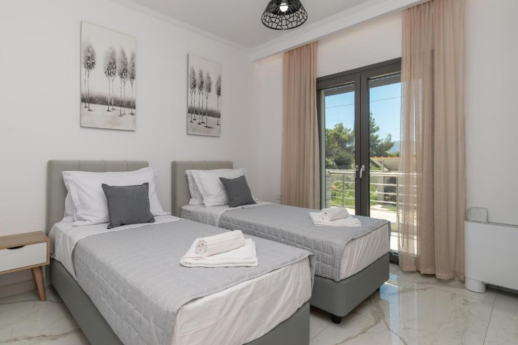 a bedroom with two beds and a balcony at Zante Escape Suites by "elite" in Laganas