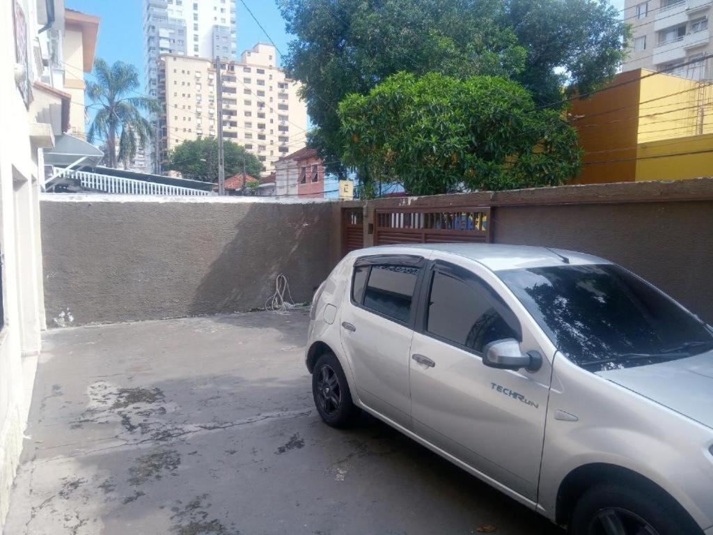 une petite voiture blanche garée sur un parking dans l'établissement Nova Casa Studio Mega - Qto1 c Ar - 3 Vagas Garagem - Esp Térreo Priv - WiFi 300 Megas - Home Office a 200 mts Praia da Pompéia, à Santos