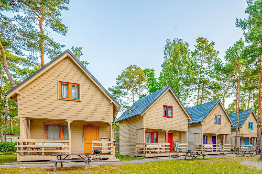 a row of houses with picnic tables in front of them at Kolorowe Domki in Pobierowo
