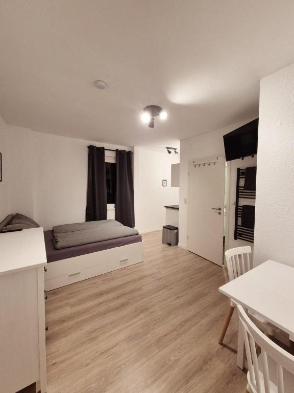 a bedroom with a bed and a kitchen and a table at Gemütliche 1-Zimmer-Dachgeschosswohnung in Hildesheim