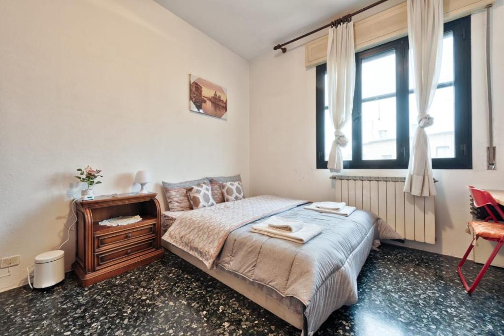 a bedroom with a bed and a dresser and windows at Easy old city in Venice