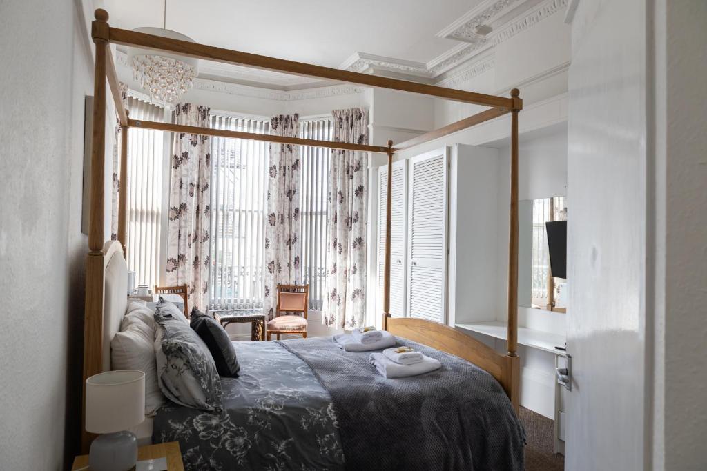 een slaapkamer met een bed en een groot raam bij Carlton House Scarborough in Scarborough