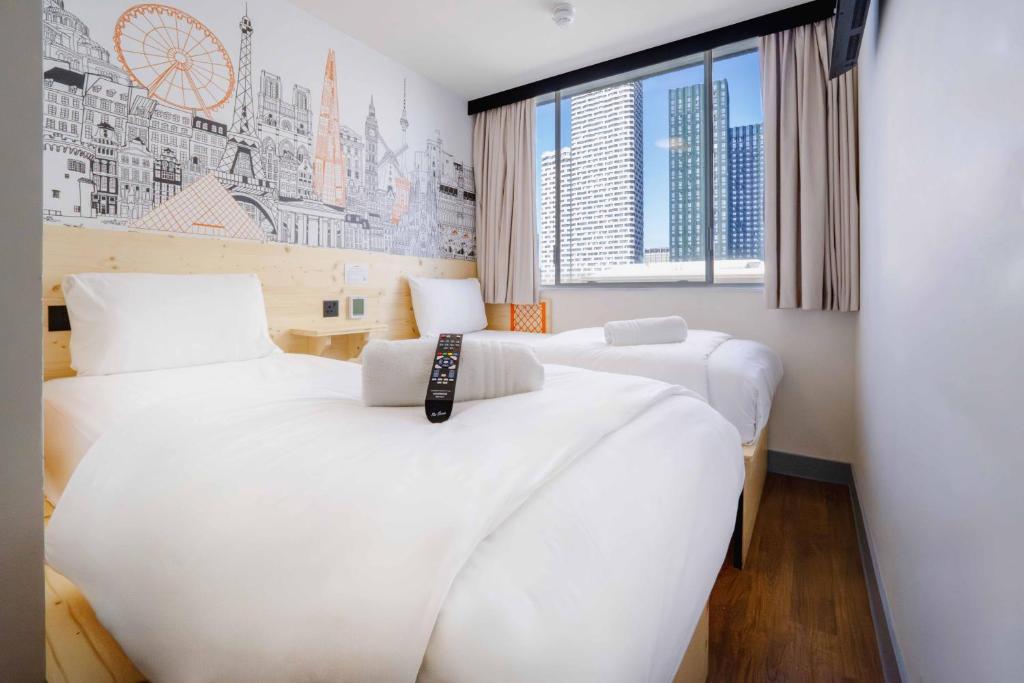 a bedroom with two beds and a window at easyHotel Croydon in Croydon