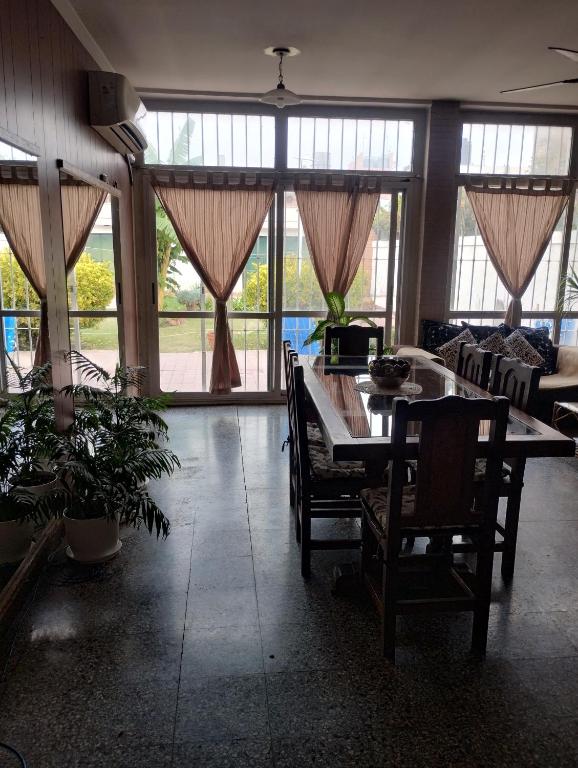 a living room with a table and chairs and windows at Toto in San Juan