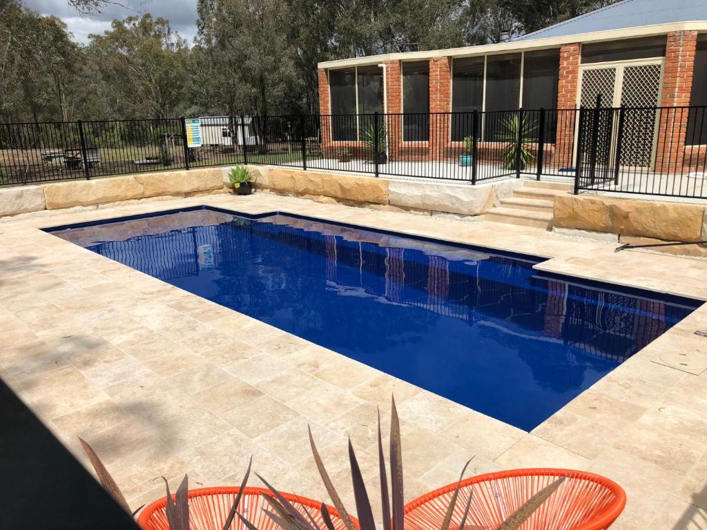 a swimming pool with blue water in a yard at Amelia Rose Estate in Lovedale