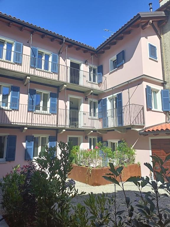 a large apartment building with blue balconies and plants at La Corte dei Mercanti by Stresahome - Centro Storico in Stresa