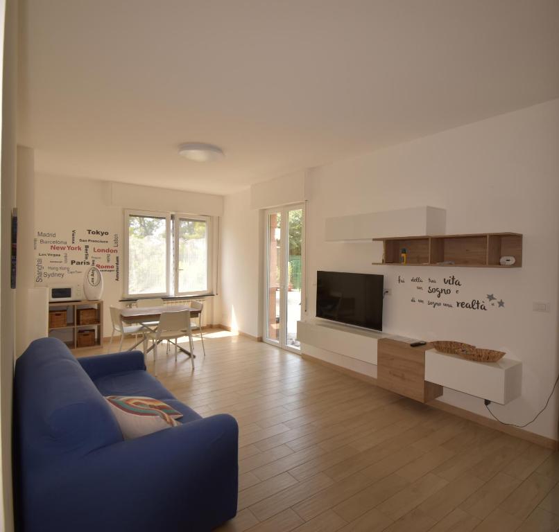 a living room with a blue couch and a tv at Casa Lorica in Pieve Ligure