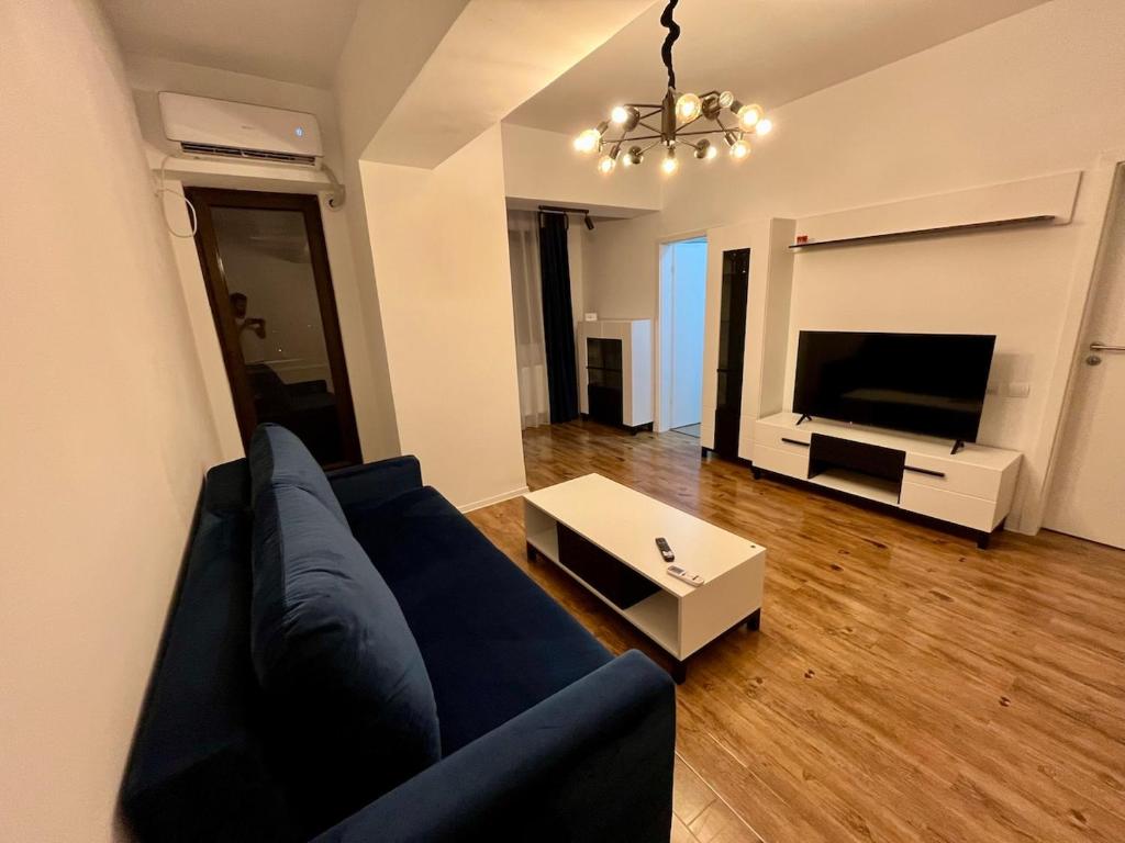 a living room with a blue couch and a tv at Ap nou cu 2 camere in centrul Bucureștiului in Bucharest