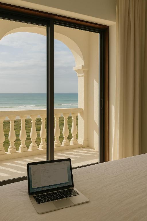 a laptop sitting on a table in front of a window at Casa da Praia in Paredes da Vitória