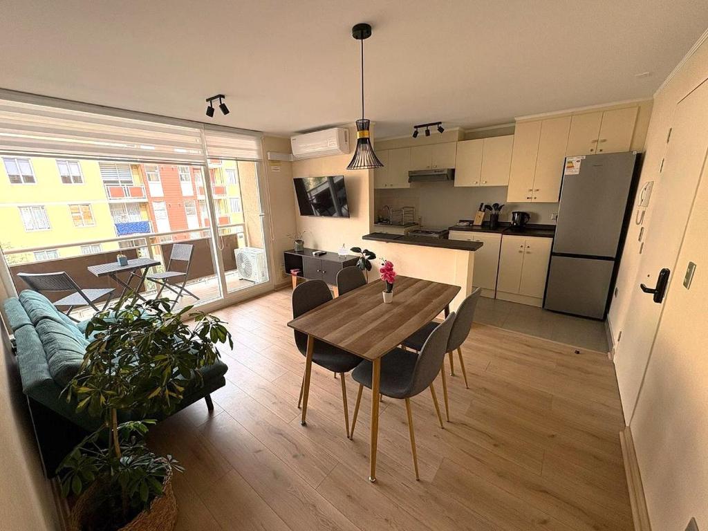 Il dispose d'une cuisine et d'un salon avec une table et des chaises en bois. dans l'établissement Departamento en Villarrica, à Villarrica