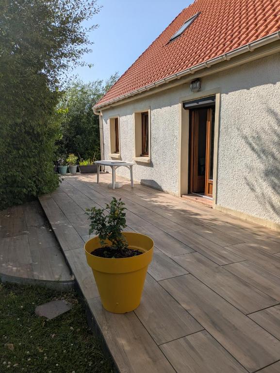 un grand pot jaune posé sur une terrasse en bois dans l'établissement Chez Nath, à Wimille