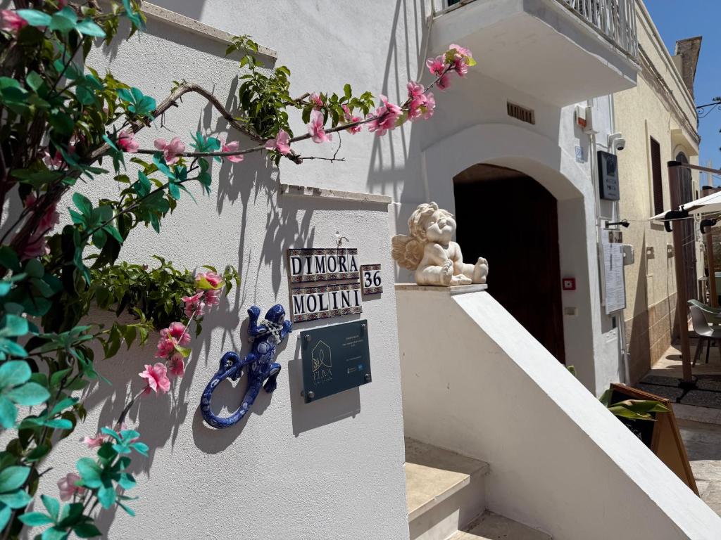 a white building with a do not disturb sign and flowers at DIMORA MOLINI in Monopoli