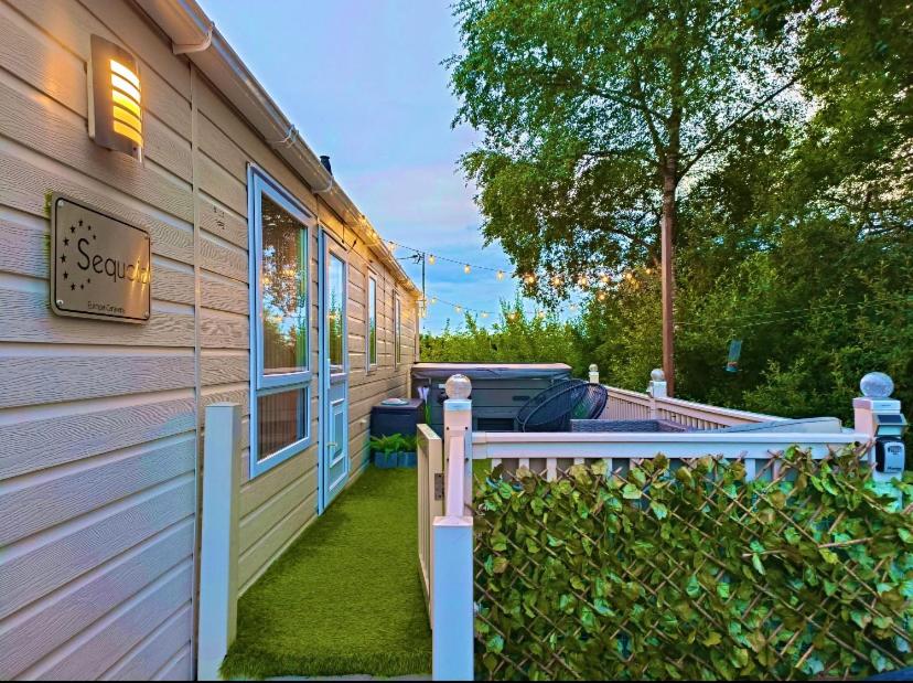 a house with a fence in front of it at Otters Rural Retreat - Private Hot-Tub & Free Golf for guests included in Swarland