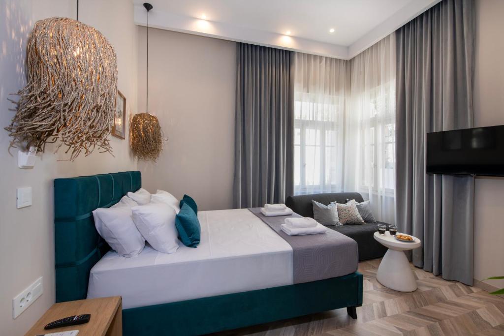 a bedroom with a bed and a couch and a television at Alba Boutique Hotel in Chania Town