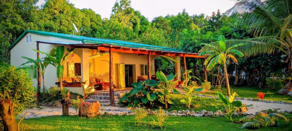 a small yellow house with a blue roof at Villa Naicha in Sainte Marie