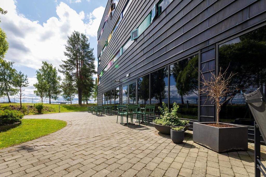 a building with tables and chairs outside of it at Comfort Hotel RunWay in Gardermoen