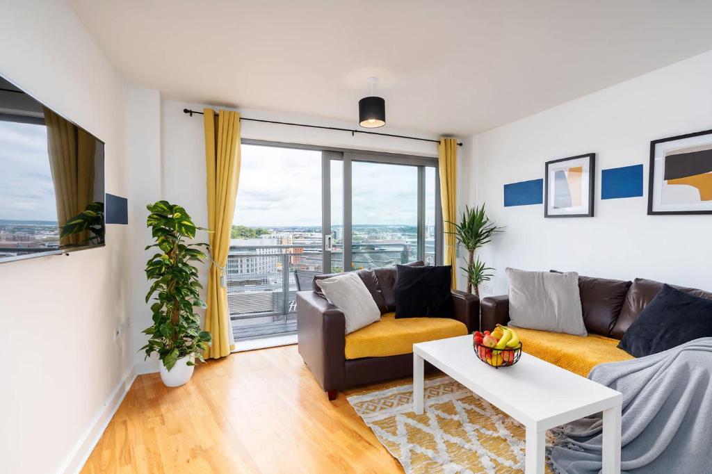 a living room with a couch and a table at Stylish 2BR Apartment near Sheffield City Centre in Sheffield