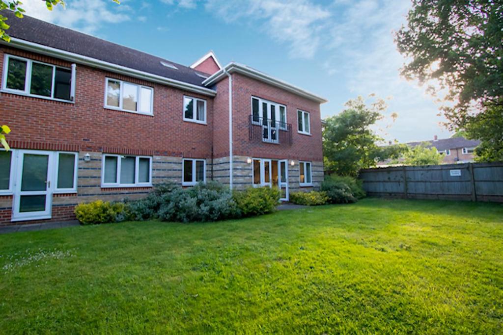 a brick house with a yard in front of it at Bracknell Spacious Two Bedroom Apartment in Bracknell