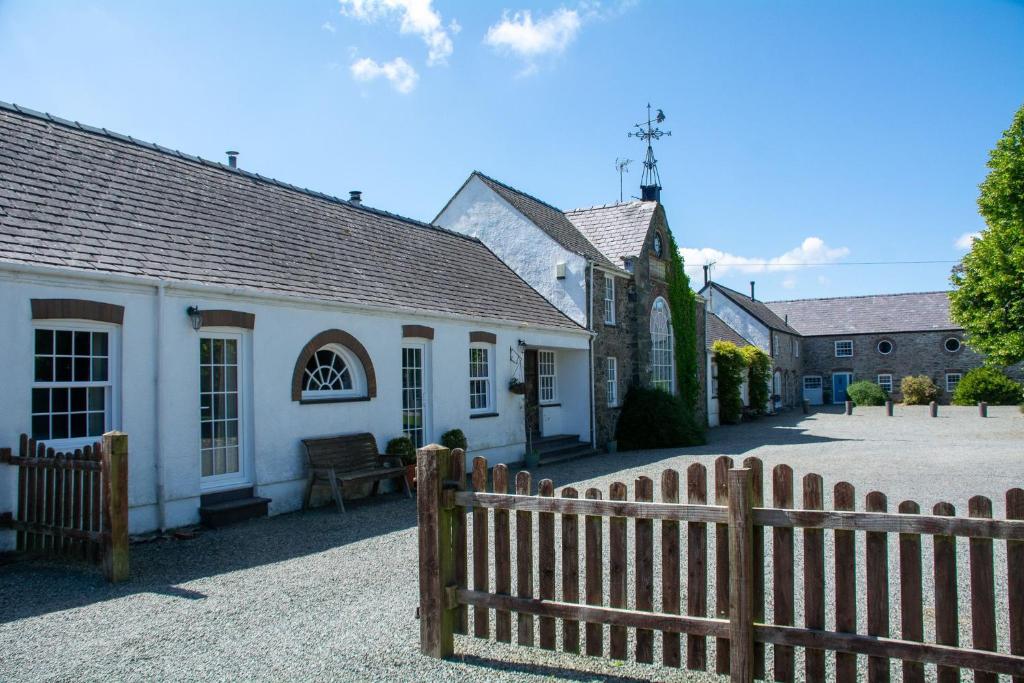 a wooden fence in front of a white building at Gamekeepers Cottage in Holyhead