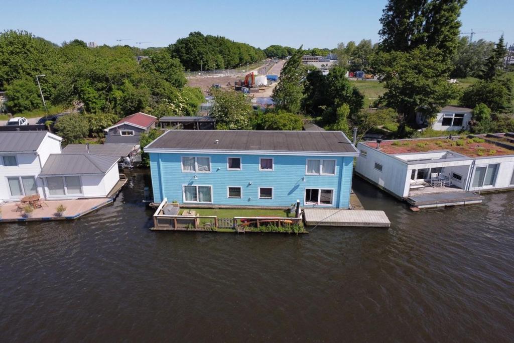 a blue house on a dock in the water at Amster Houseboat Bed without Breakfast in Amsterdam