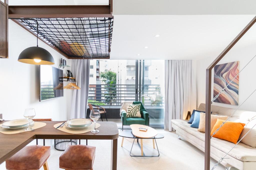 a living room with a table and a couch at DNA Vila Mariana - Studios por temporada in Sao Paulo