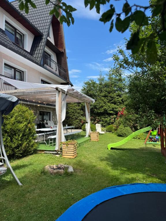 Zubrzyca GórnaにあるWolna chataのテーブルと緑の滑り台のある裏庭
