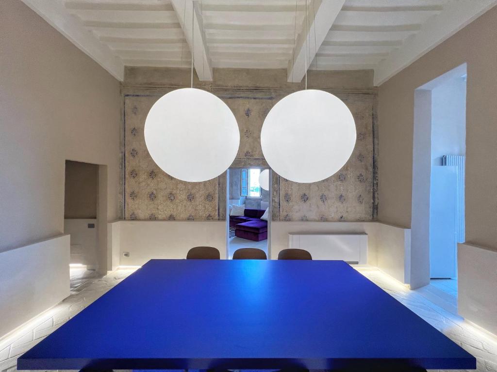 Una sala de reuniones con una mesa azul y dos orbes blancos. en Residenza Neri-Serneri, en Foiano della Chiana
