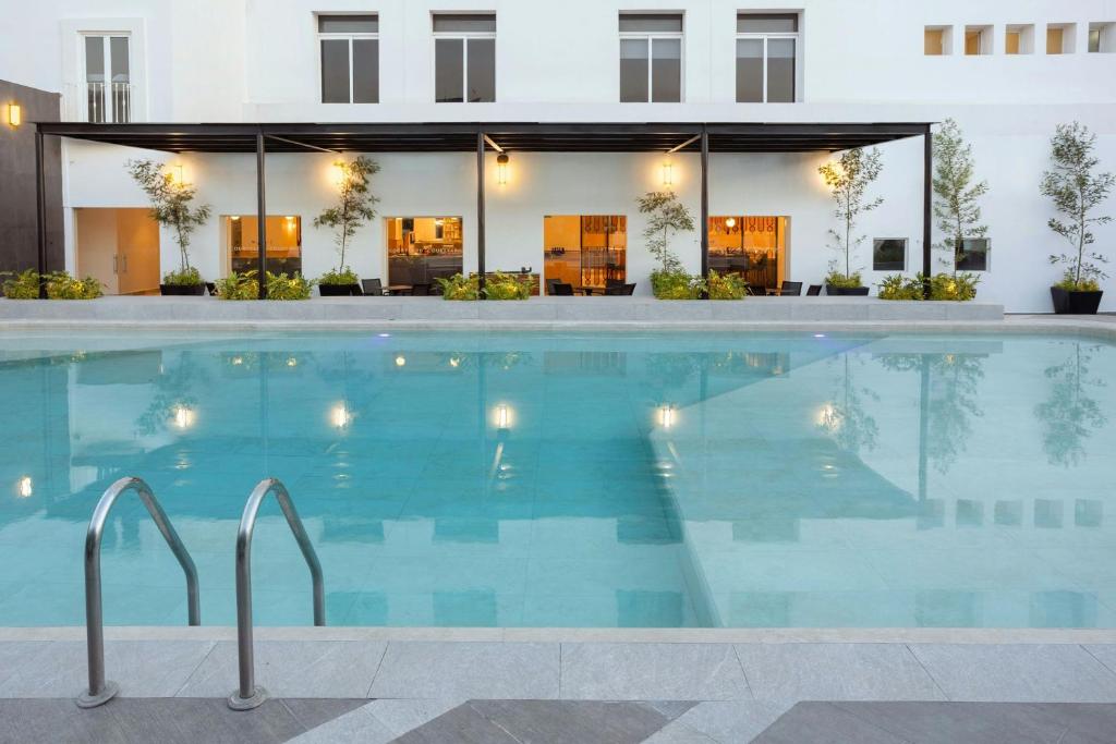a swimming pool in front of a building at Courtyard by Marriott Puebla Las Animas in Puebla