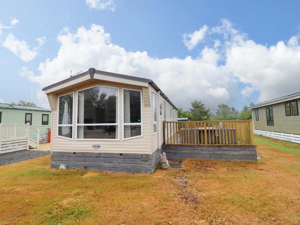 a tiny house sitting on top of a yard at Beach Retreat E19 Dyffryn Seaside Estate in Dyffryn