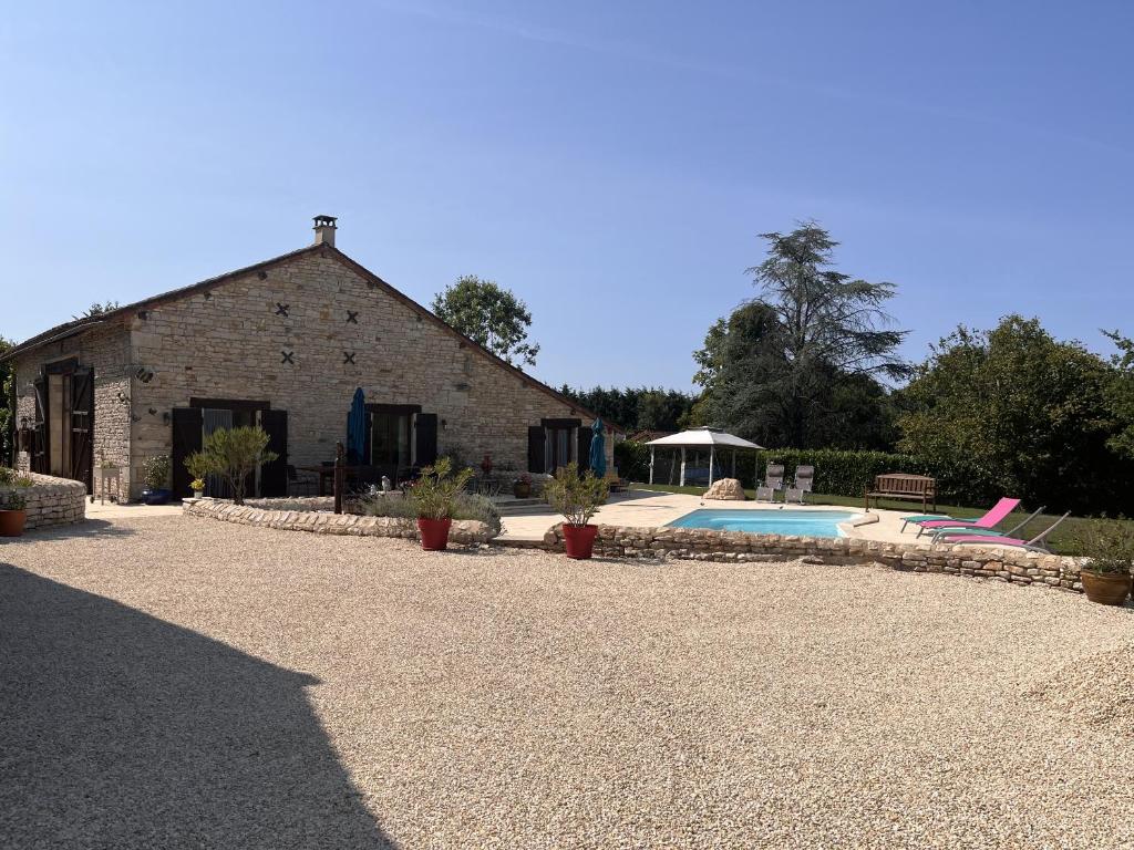 - un bâtiment en pierre avec une piscine en face dans l'établissement Maison M, à Surin