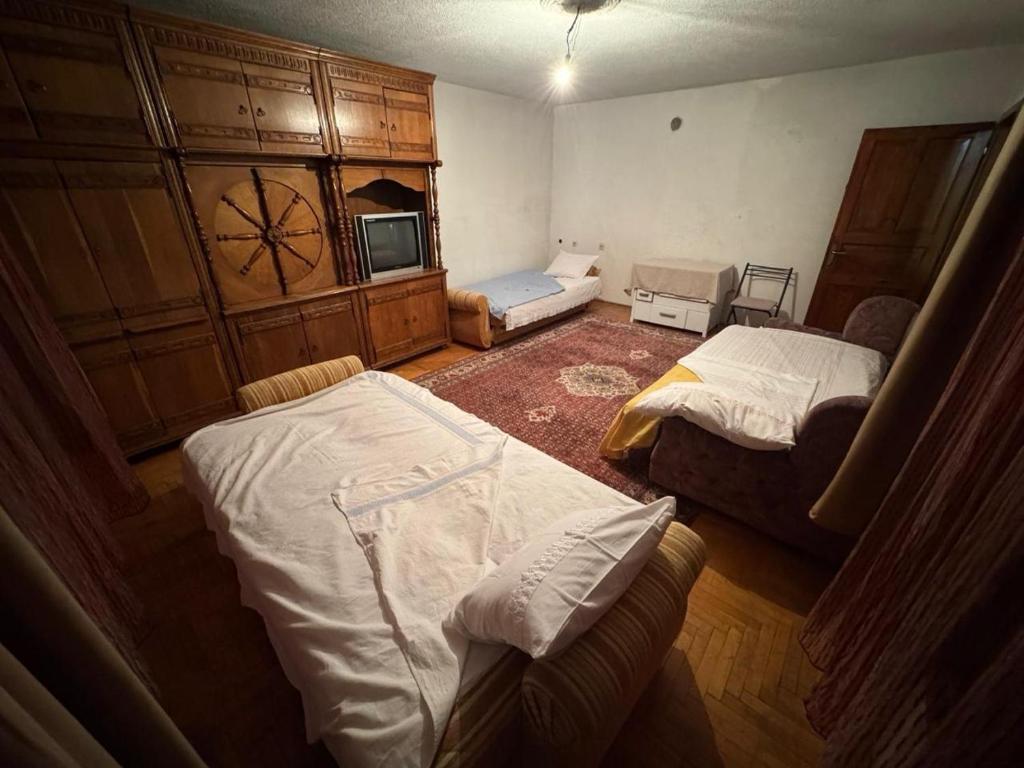 a small room with two beds and a couch at Drenis Home in Prizren