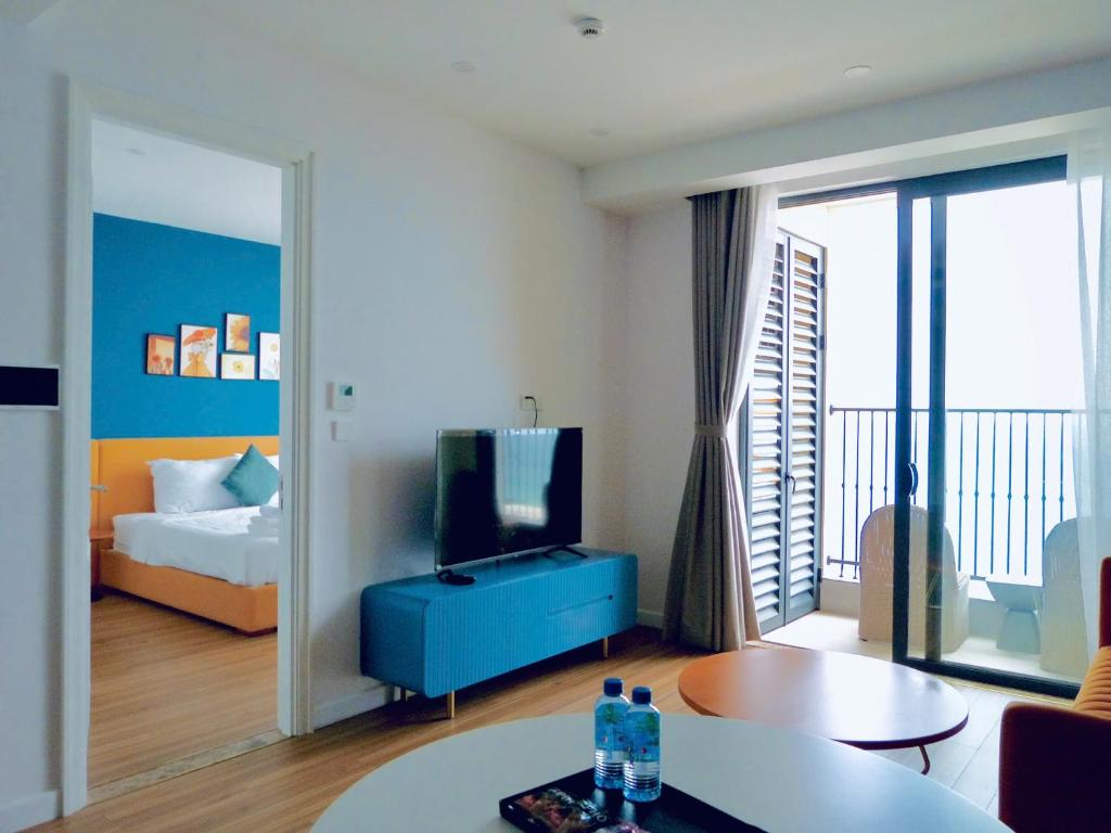 フーコックにあるAura Aparmentのベッド、テレビ、リビングルームが備わる客室です。