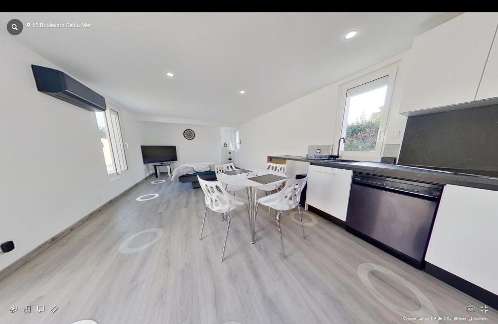a living room with a kitchen and a table and chairs at Maison individuelle Aytré plage terrain clos 280m2 très calme in Aytré