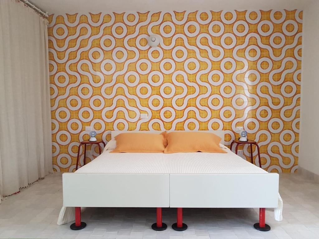 een wit bed in een kamer met een muur bij Dammusino A-mare in Pantelleria