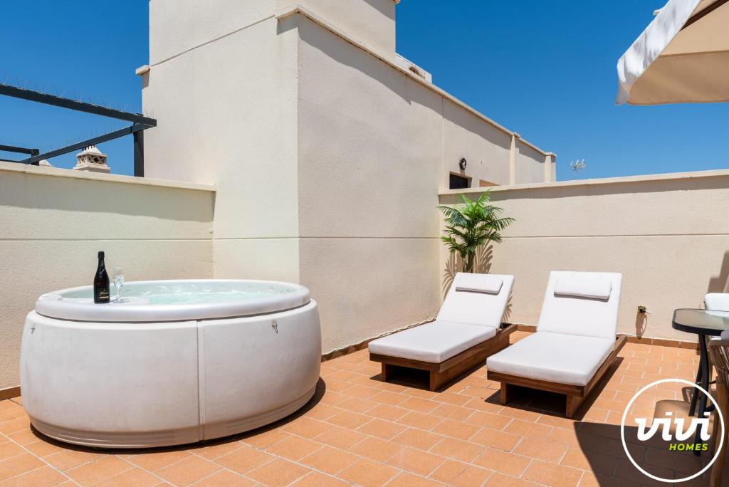 a hot tub and two chairs on a patio at Casa Fina in Estepona