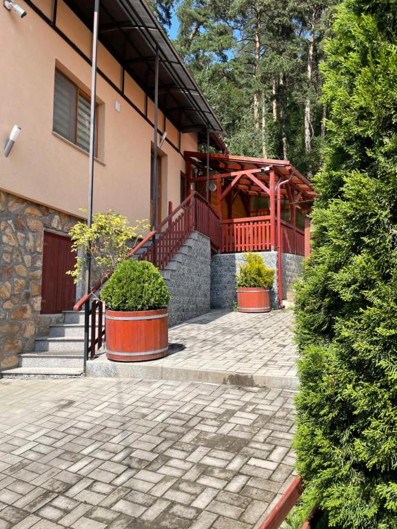 a house with a brick walkway and a building at Ambrus vendégház in Gheorgheni