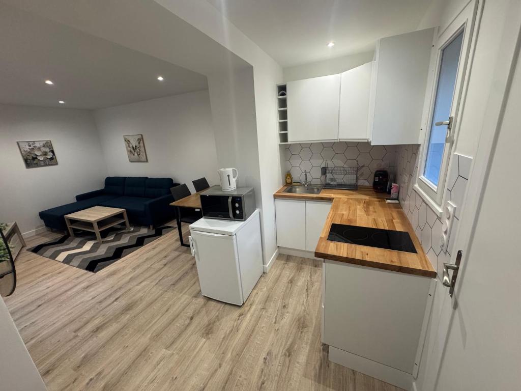 a kitchen and living room with a couch and a table at Maison Merveilles 4 in Saint Malo