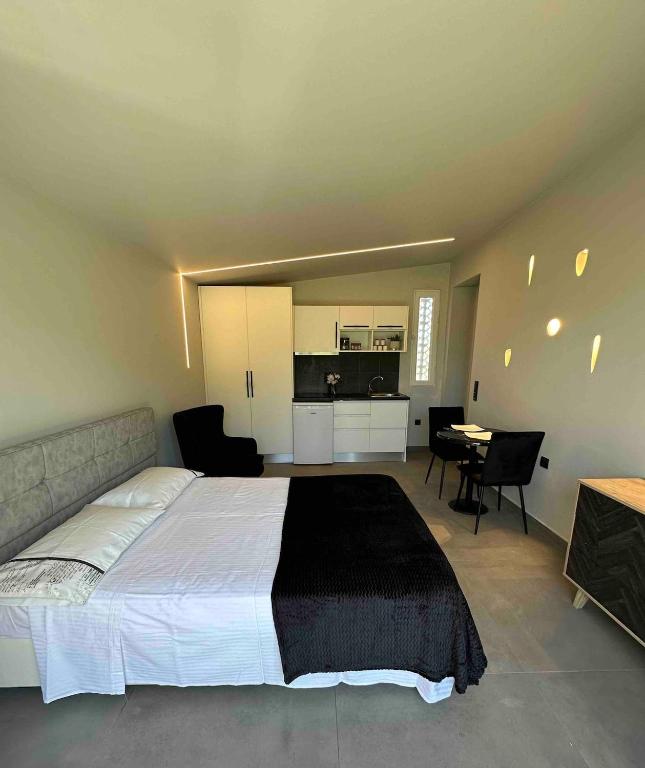 a bedroom with a bed and a table and a kitchen at Charming Retreat in Mesochórion