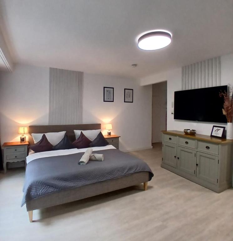 a bedroom with a large bed and a flat screen tv at RELAX INN - Messe contactless check in in Hannover