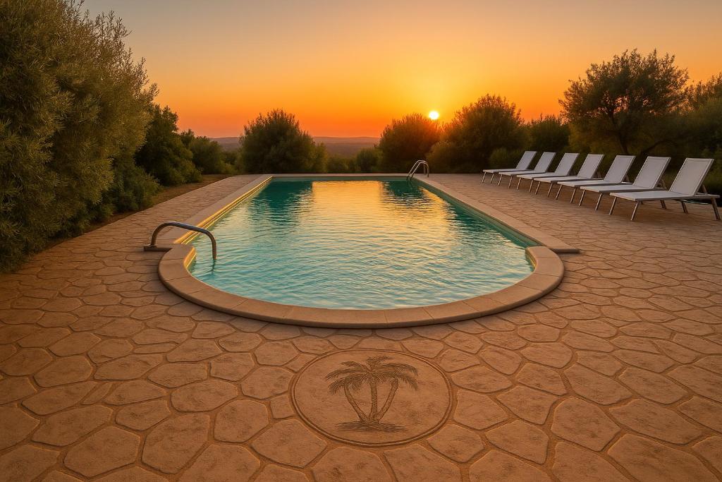 a pool with chairs and a sunset in the background at Villa Mira Exclusive with Pool- Noto Sicily in Noto Marina