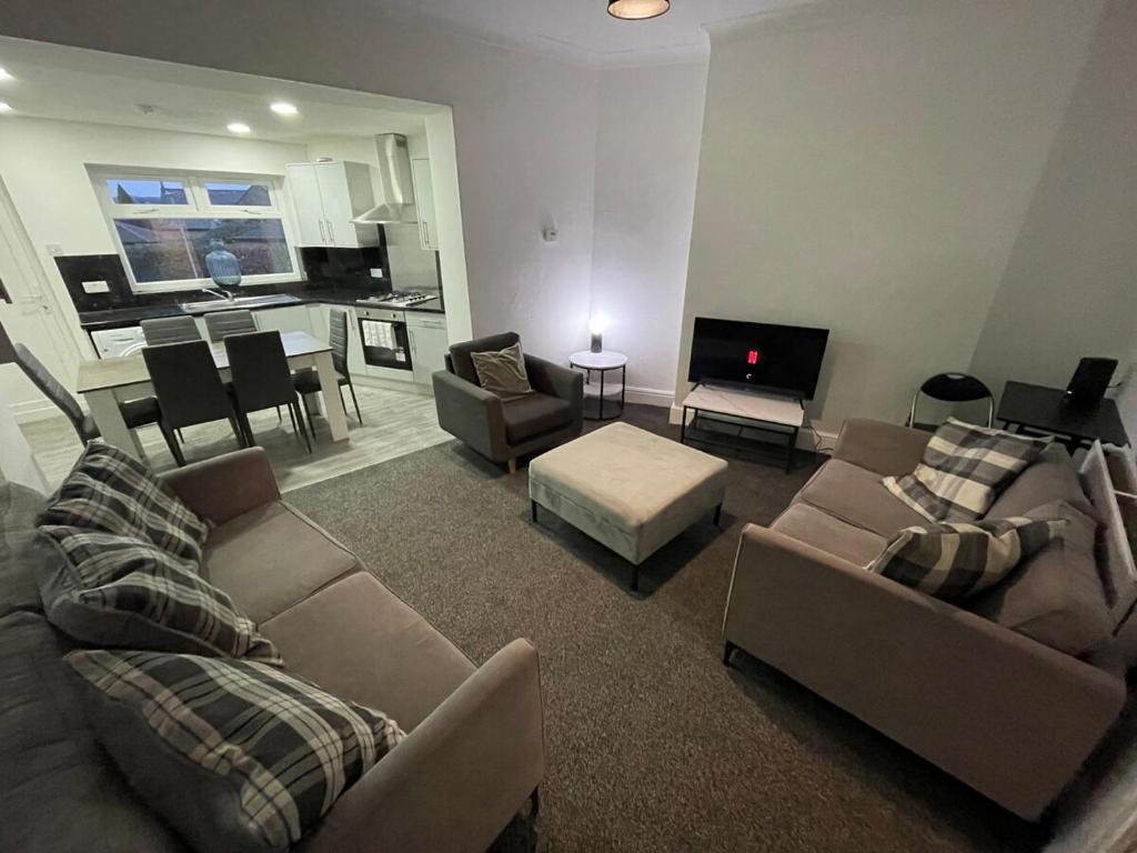 a living room with two couches and a tv at Modern Five Bed Long Stays and Contractors Welcome in Burnley