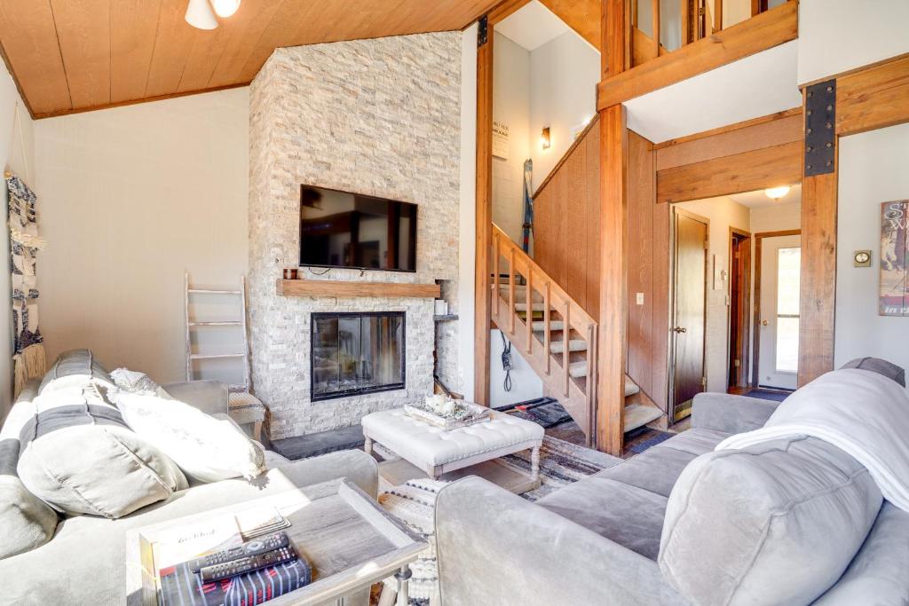 a living room with a fireplace and a stone wall at Charming Townhome - Walk to Greek Peak Mountain! in Cortland