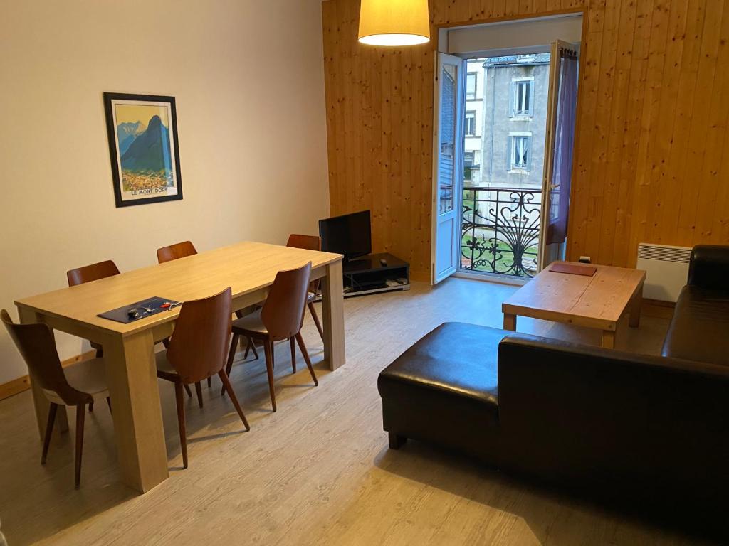a living room with a table and chairs and a couch at Val-locations la paix 7 in Le Mont-Dore