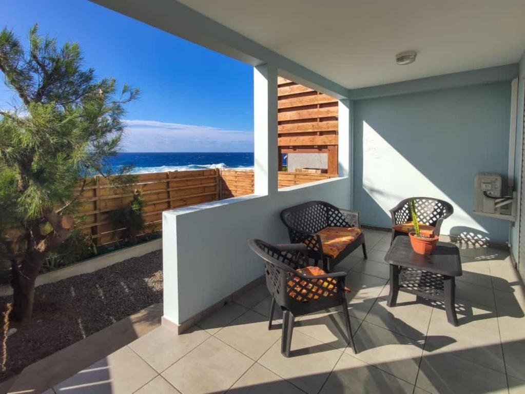 Un patio con sillas y vista al mar. en KAP Alizés RDC appartement face à l'océan, en Saint-Pierre