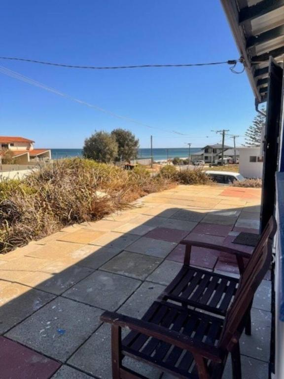 a bench sitting on a sidewalk near the beach at Vintage Ledge Point Beach Shack in Ledge Point