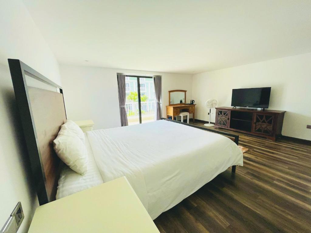 a bedroom with a large white bed and a television at lalahouse6 in Khu Chi Lăng
