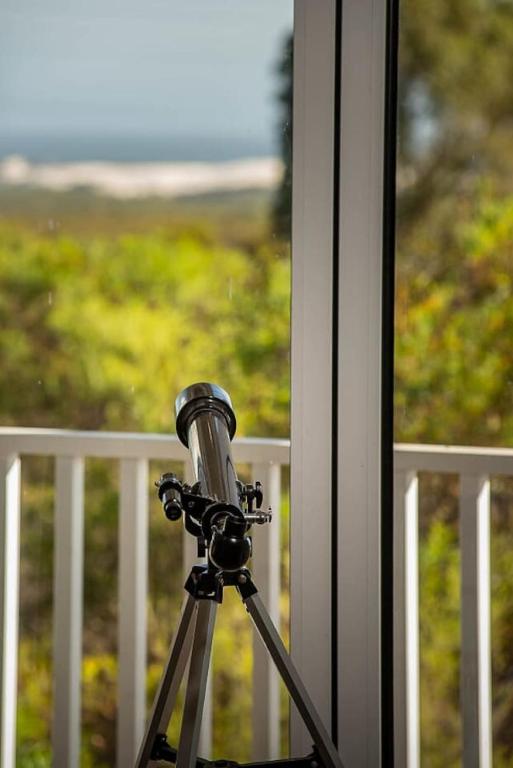 a camera on a tripod in front of a window at Stunning Lookout Lancelin in Lancelin