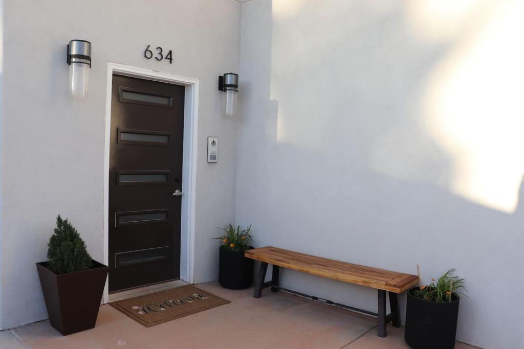 Una puerta y un banco de madera delante de una puerta. en Juniper Heights 2 Bed 2 Bath and Hot Tub, en Kanab