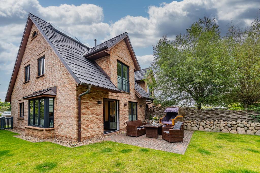 a brick house with a table and chairs in a yard at Gode Stuv in Westerland