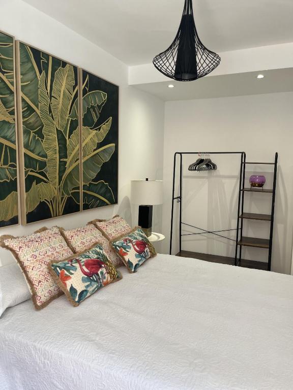 a bedroom with a white bed with a painting on the wall at Apartamento Blancanieves in Brihuega